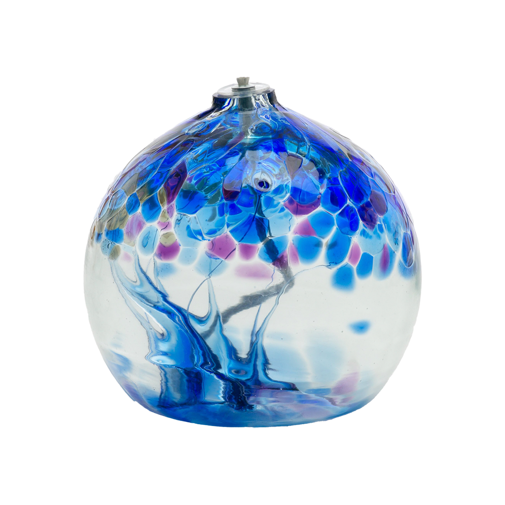 Flat bottom clear glass orb with a wick with blue and purple glass pulled through the middle and purple and blue bits on top on a transparent background.