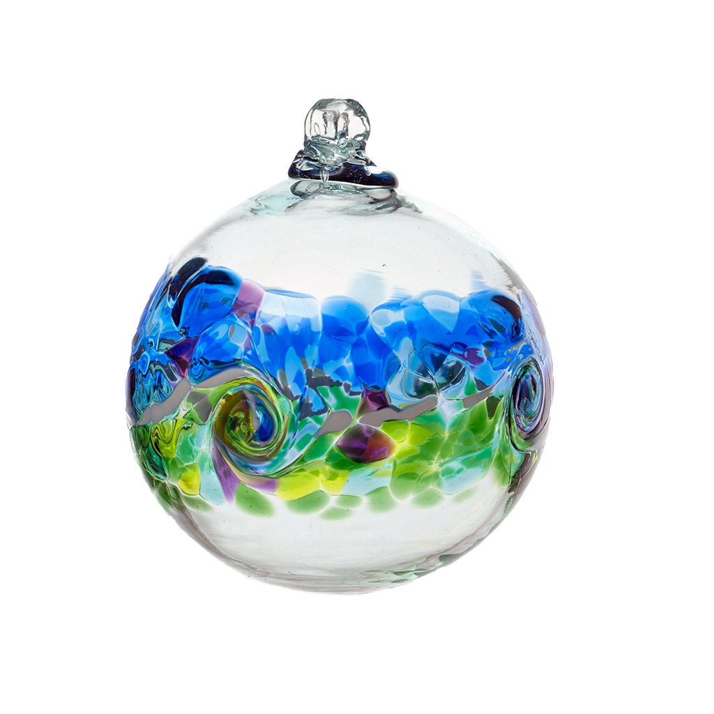 Glass orb with a band of colour around the middle. Blue and purple on top, a white band of opaque glass swirled in the middle and green and purple glass below on a transparent background