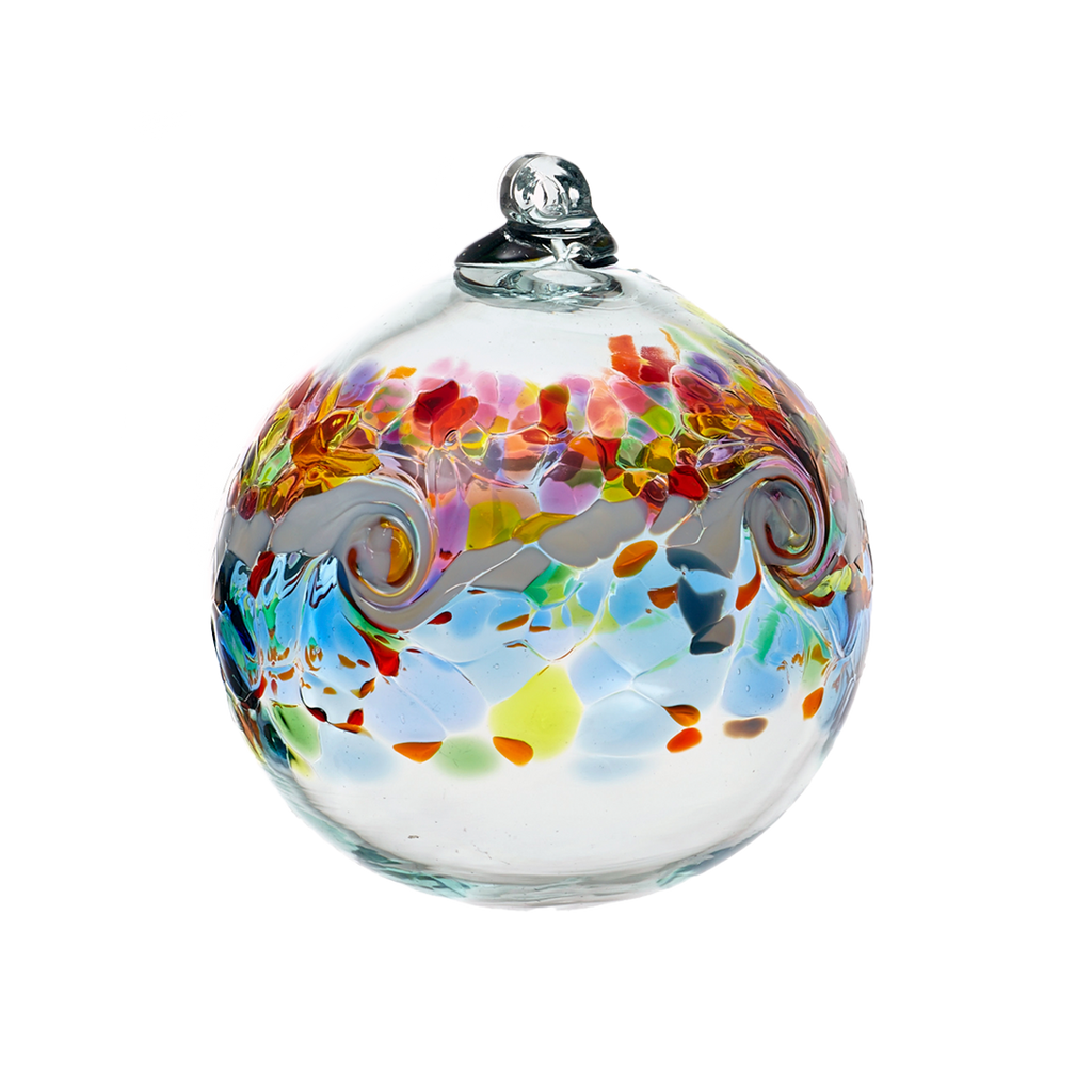 Glass orb with a band of colour around the middle. Red, purple and pink on top, a white band of opaque glass swirled in the middle and blue, yellow, orange and green glass below on a transparent background