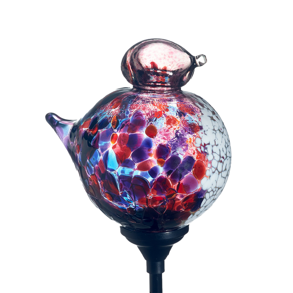 Glass bird with purple, pink and blue mosaic along the surface, pink head and opaque white on chest with a black clip on a transparent background.