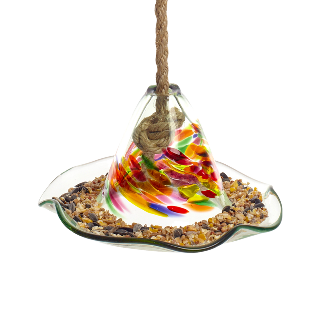 What looks like a glass hat with a ripple brim full of birdseed. The cone of has orange, purple, red, green and yellow glass swirled into clear glass. A rope comes out of a hole in the top. 