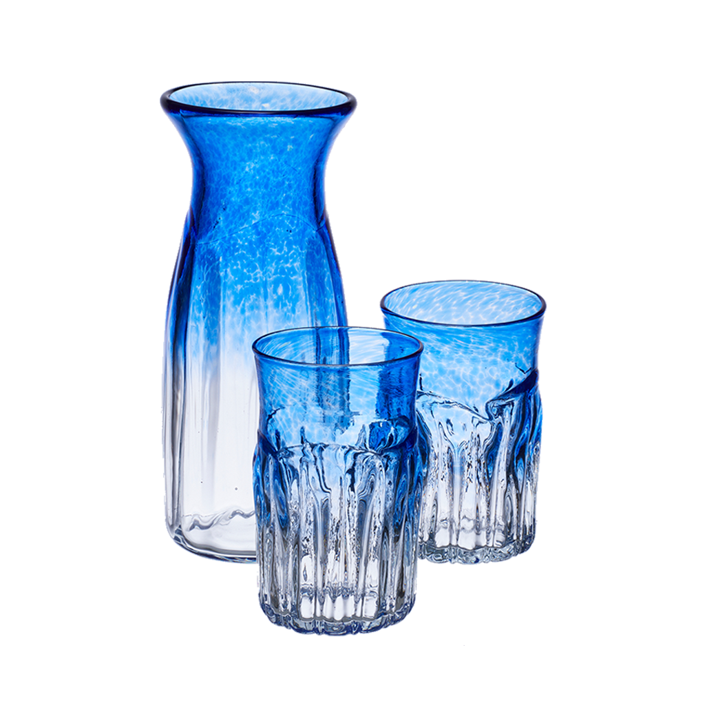 Carafe and two glasses with clear glass on the bottom and blue glass on the top. On a transparent background.
