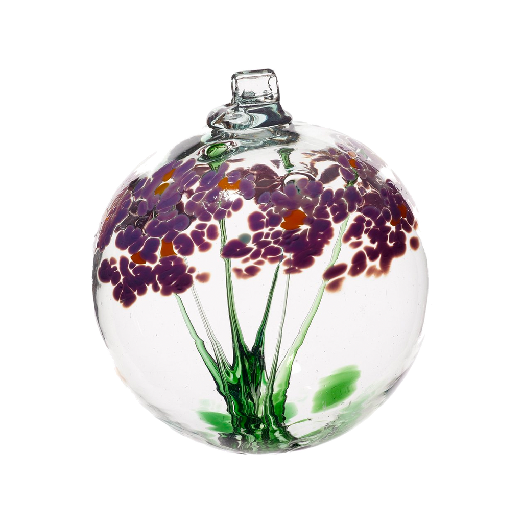 Clear glass orb with flat bottom and a wick with a green stem pulled from bottom to top to a canopy of purple opaque glass blossoms and orange centres on a transparent background
