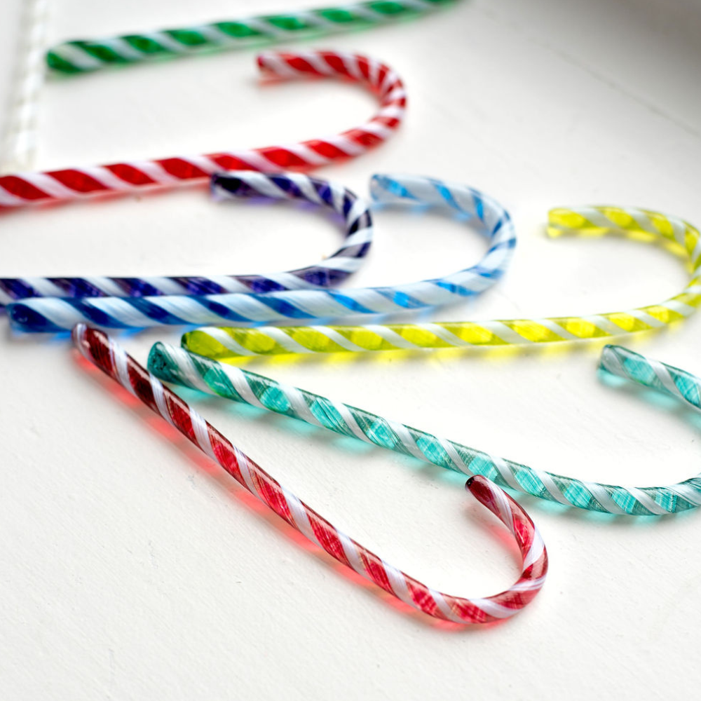 Assortment of glass Candy Canes displayed on a white surface. 