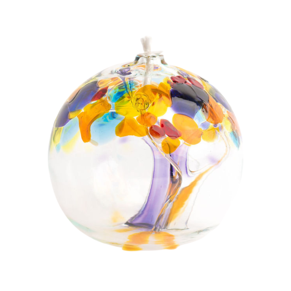Clear glass orb with purple and orange glass pulled through the middle and yellow, red, purple, orange, green and blue bits on top on a transparent background.