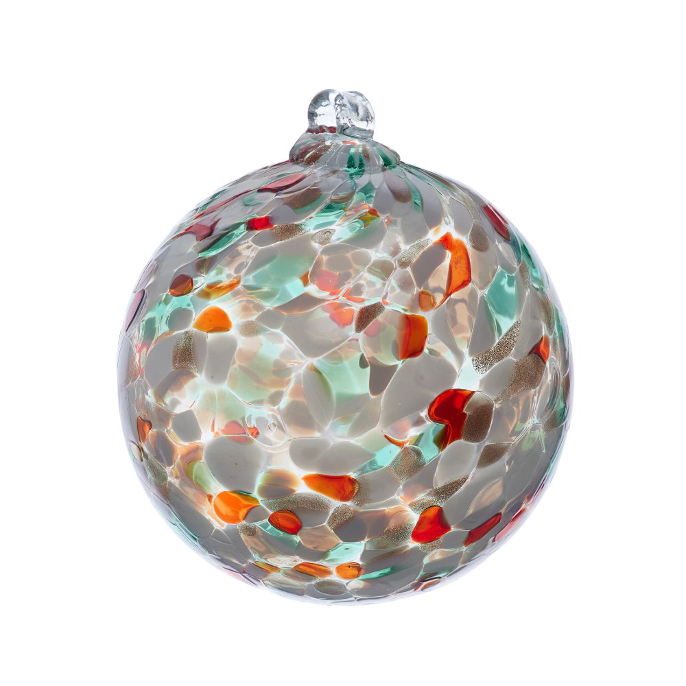 Round glass ball with green, red and opaque white glass mosaiced around the entire surface on a transparent background.