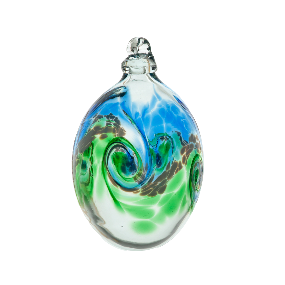 Oval glass orb with colour around the middle. Blue on top, white swirled in the middle and green on the bottom on a transparent background.