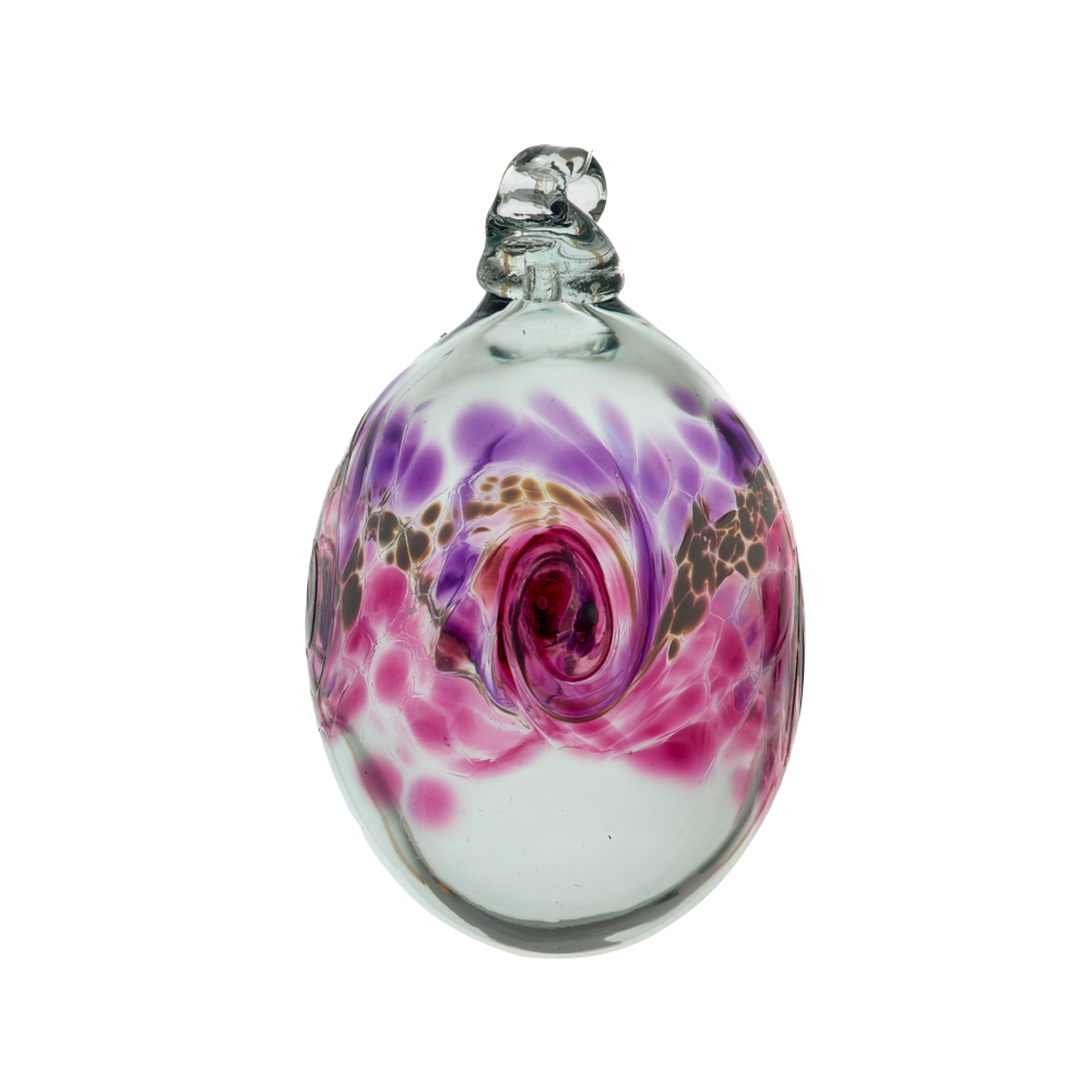 Oval glass orb with colour around the middle. Purple on top, white swirled in the middle and pink on the bottom on a transparent background.