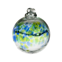 Glass orb with blue and green coloured glass around the middle and horizontal webbing on a transparent background.