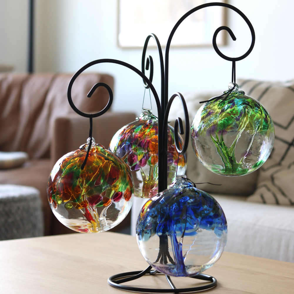 Large Quadruple Ornament Holder with all four 6" seasons Trees of Enchantment. Displayed on a livingroom table with couches in the background. 
