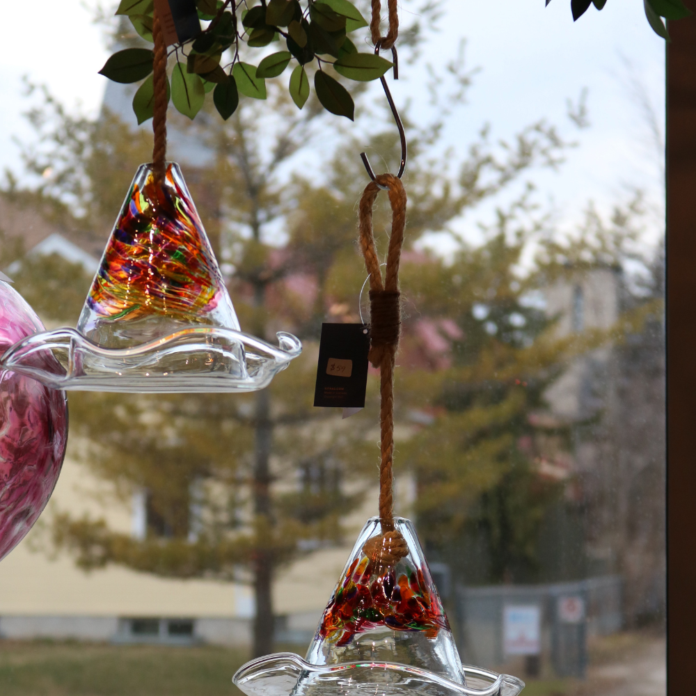 Calico Seed Rest hanging from an "S" Hook in a window.
