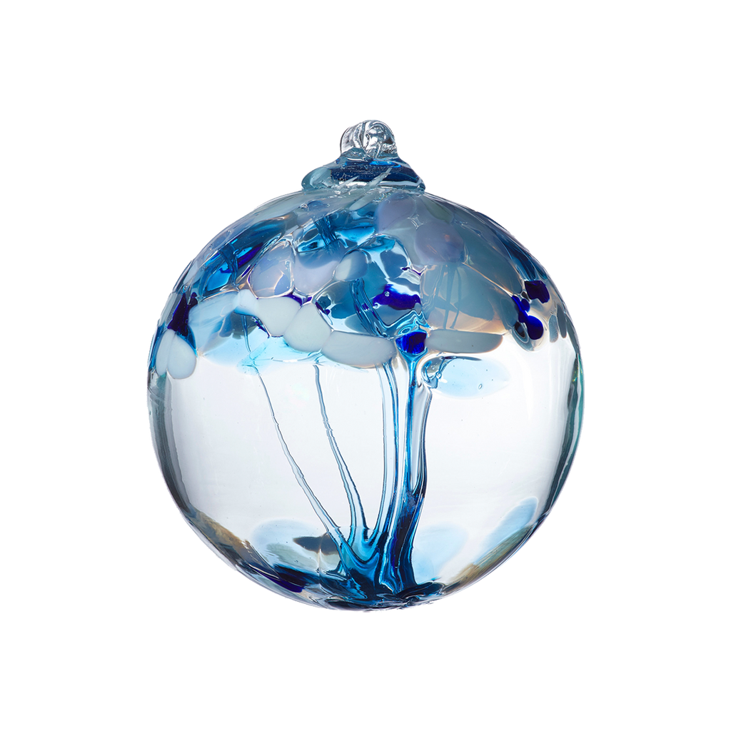 Clear glass orb with blue glass pulled through the middle and white and blue bits on top on a transparent background.