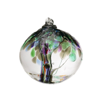 Clear glass orb with grey, purple, green and red glass pulled through the middle and red, purple, grey, green and blue bits on top on a transparent background.