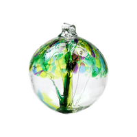 Clear glass orb with purple and green glass pulled through the middle and yGreen, Teal, Lime, Blue, Purple and Pink bits on top on a transparent background.