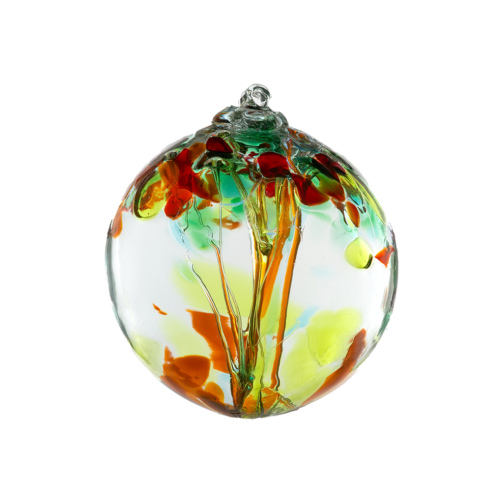 Clear glass orb with pink glass pulled through the middle and yellow, red, orange, tree and gold glitter glass bits on top on a transparent background.