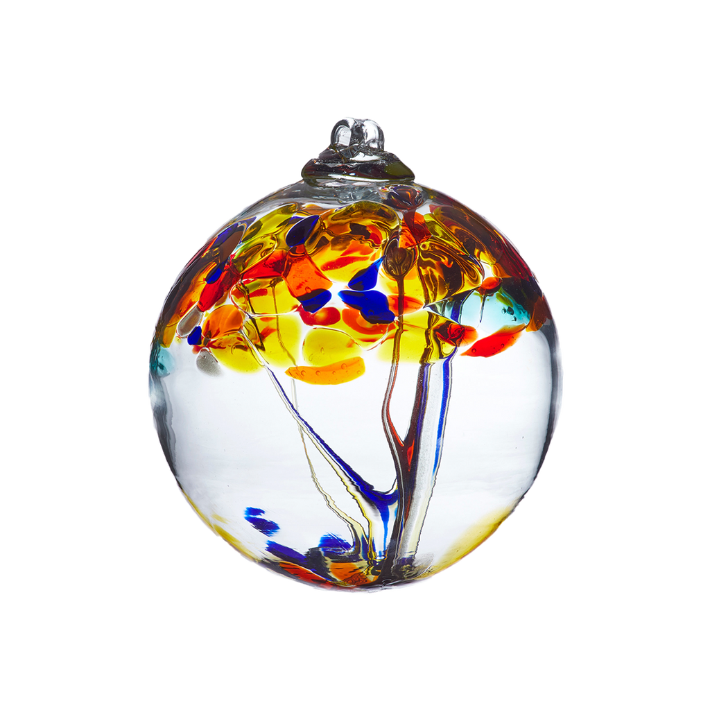 Clear glass orb with clear, orange and blue glass pulled through the middle and yellow, red, orange, gold glitter and blue bits on top on a transparent background.