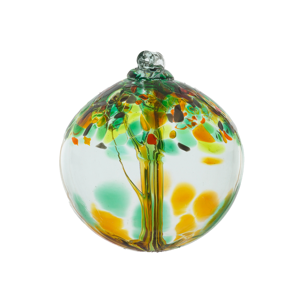 Clear glass orb with orange glass pulled through the middle and yellow, orange, grey and green bits on top on a transparent background.