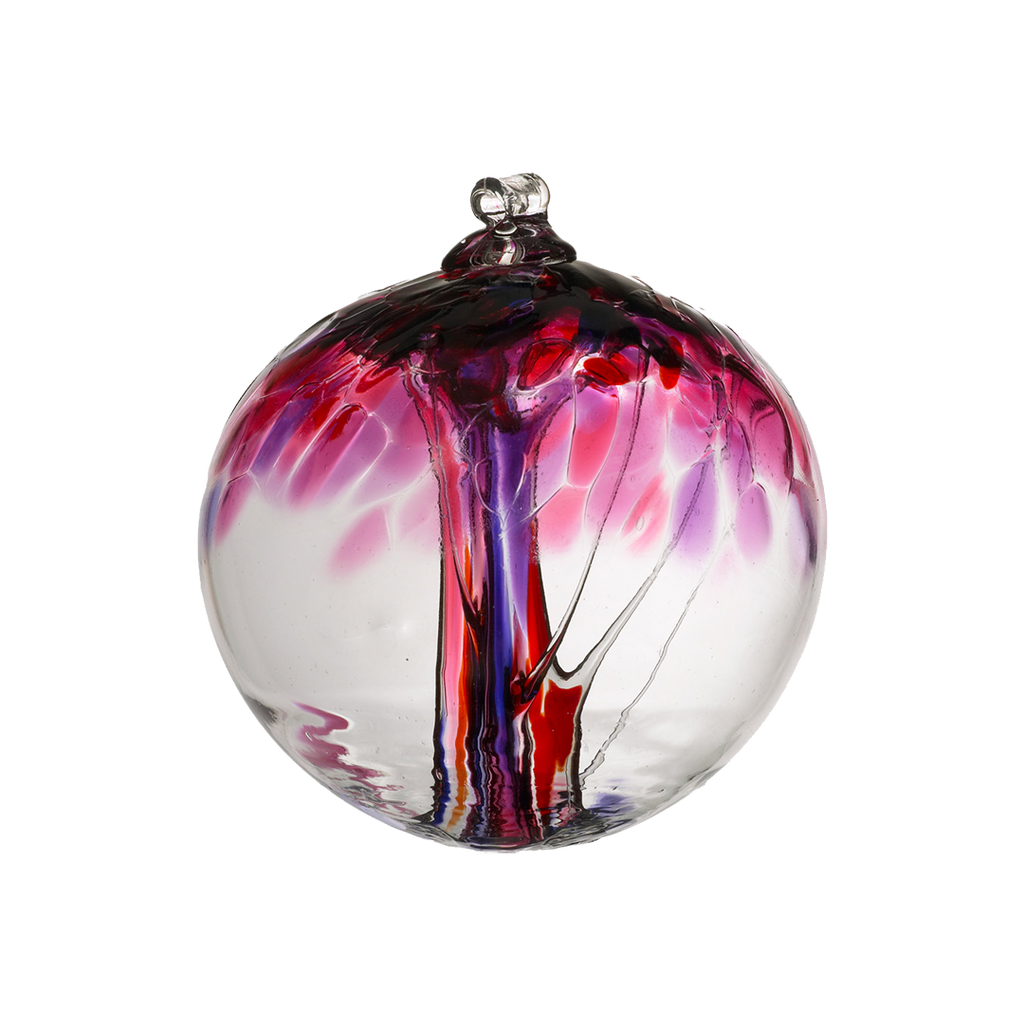 Clear glass orb with pink and purple glass pulled through the middle and red, purple and pink bits on top on a transparent background.