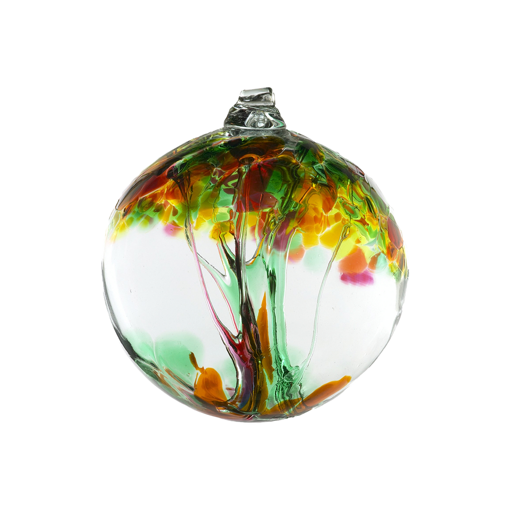 Clear glass orb with green and red glass pulled through the middle and yellow, red, pink, orange, green and brown bits on top on a transparent background.