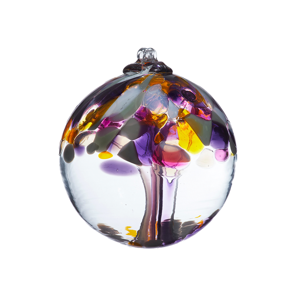 Clear glass orb with purple and pink glass pulled through the middle and yellow, white, purple and pink bits on top on a transparent background.