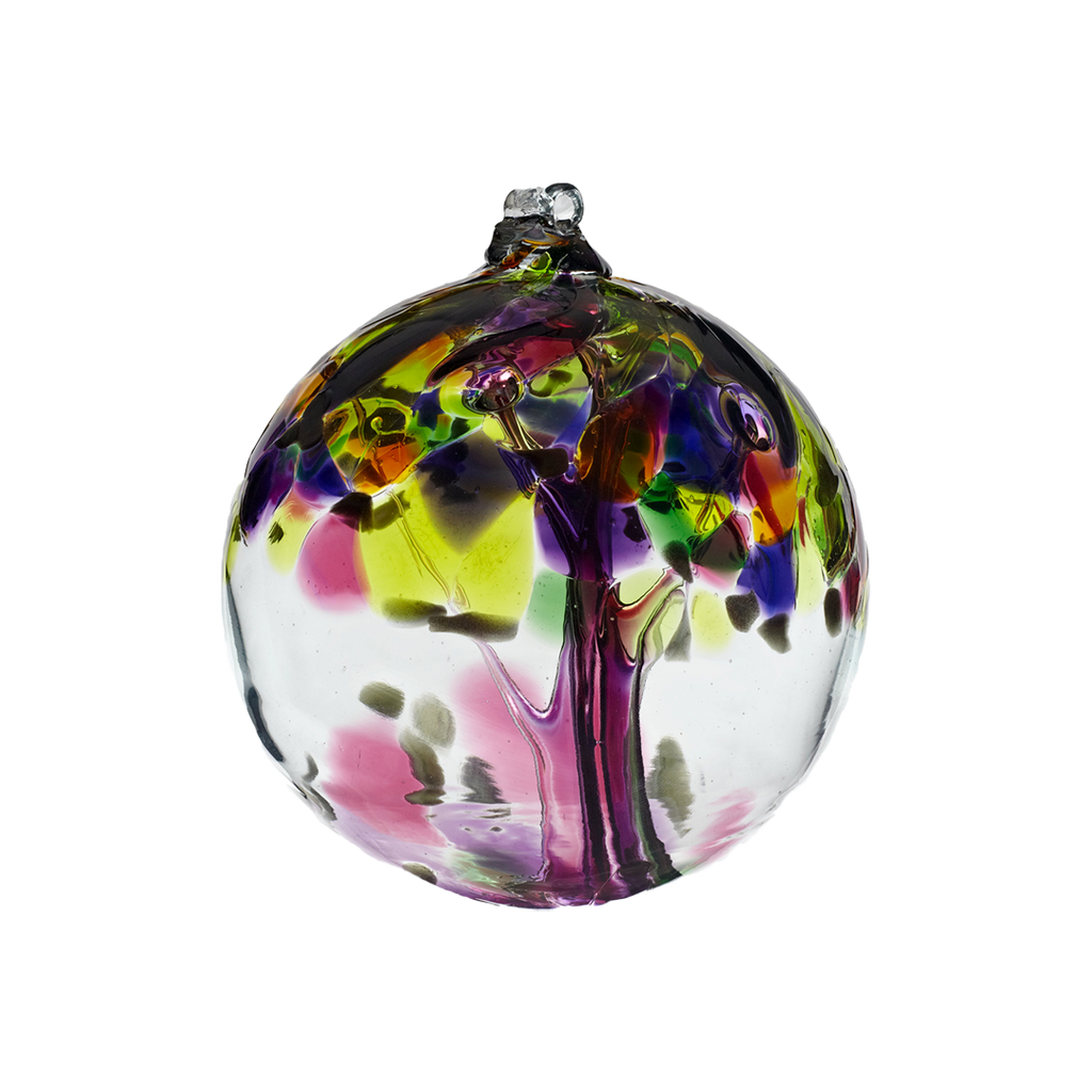Clear glass orb with pink glass pulled through the middle and purple, lime, green, blue, orange and grey bits on top on a transparent background.