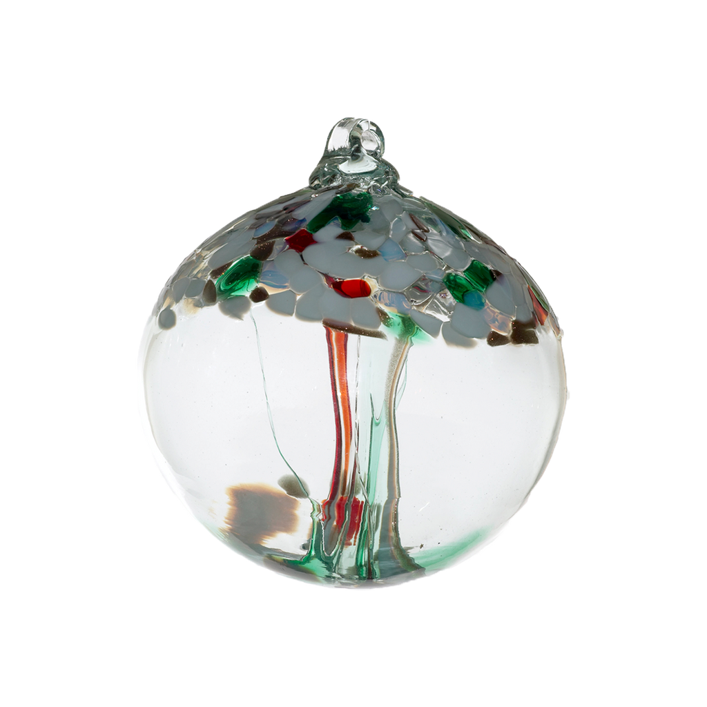 Clear glass orb with red and green glass pulled through the middle and white, red, green and gold glitter glass bits on top on a transparent background.