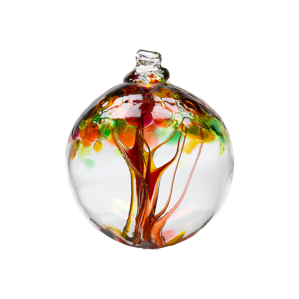 Clear glass orb with orange glass pulled through the middle and yellow, pink, orange, green and amber bits on top on a transparent background.