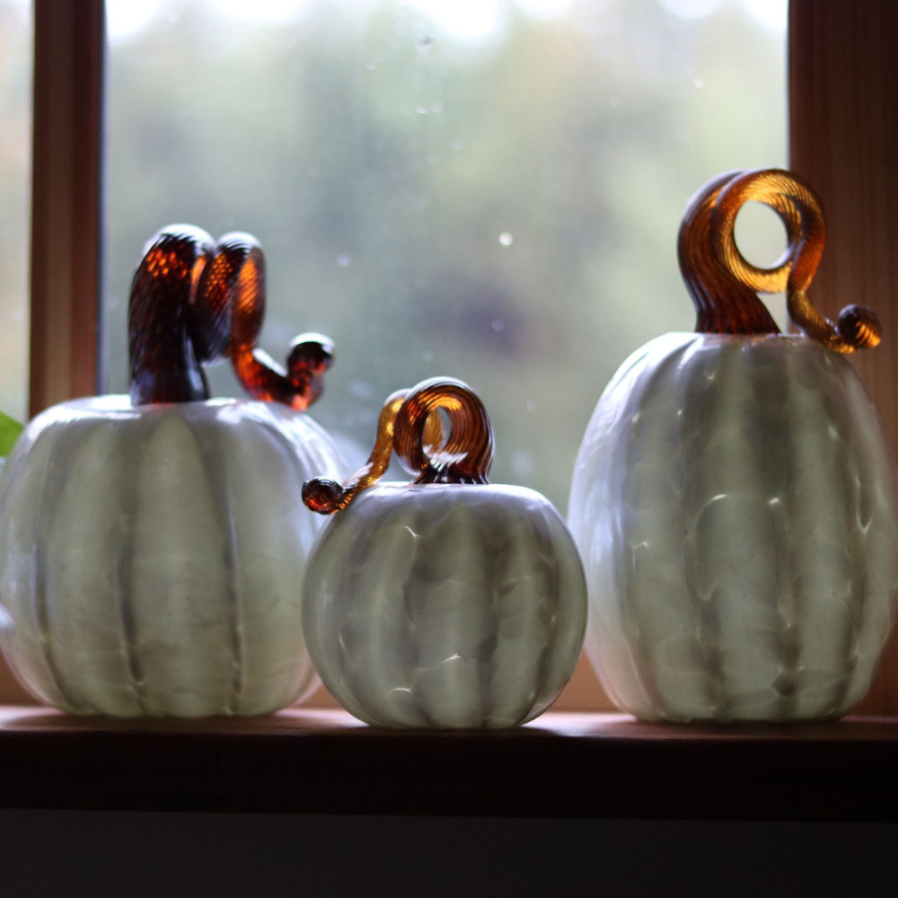 6" White Round Pumpkin, 3" White Round Pumpkin and White Oval Pumpkin on a wood window sill in front of a window