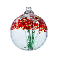  Clear glass orb with a green stem pulled from bottom to top to a canopy of red opaque glass blossoms and yellow centres on a transparent background.